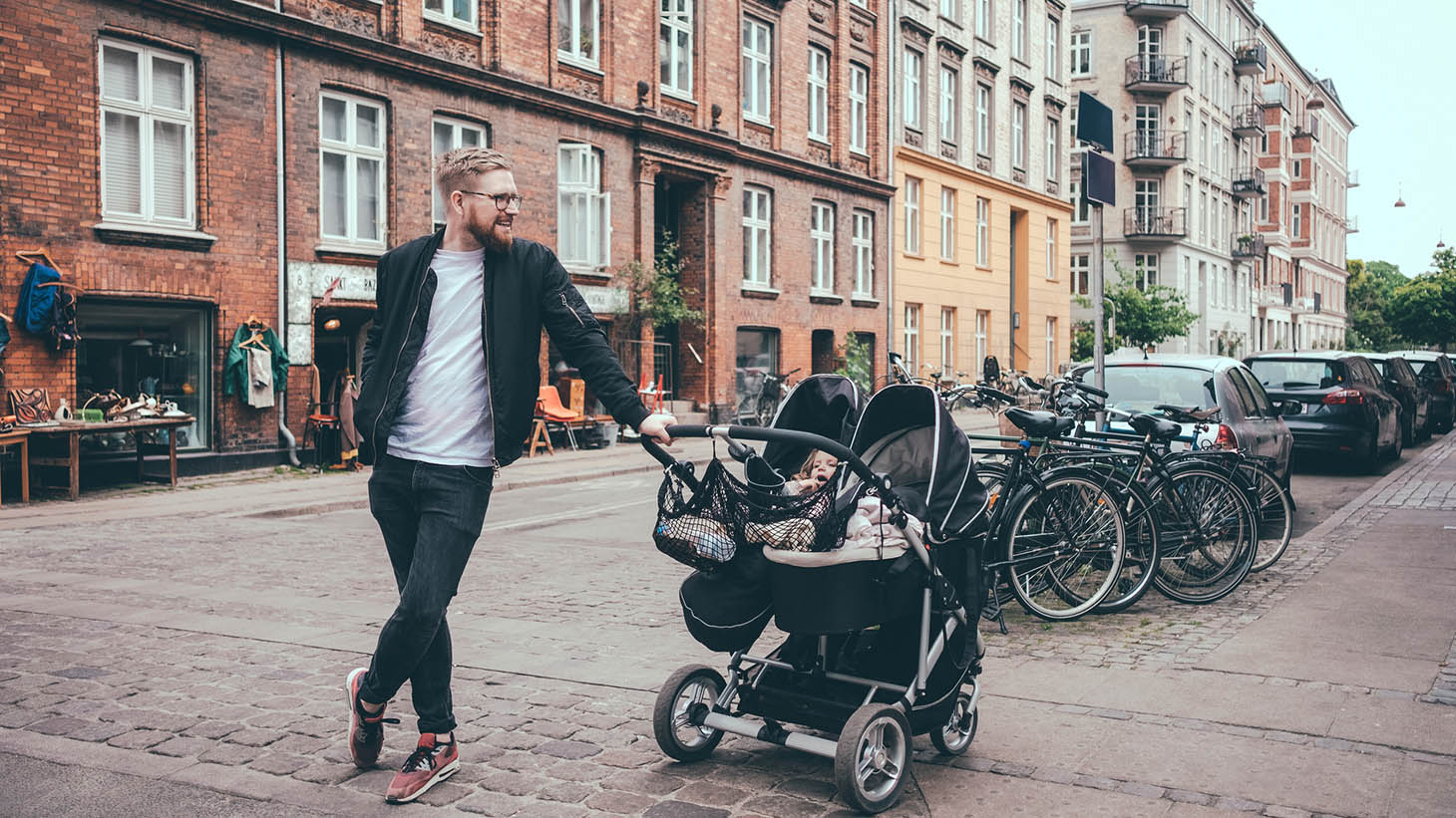 En pappa med en barnvagn i innerstaden