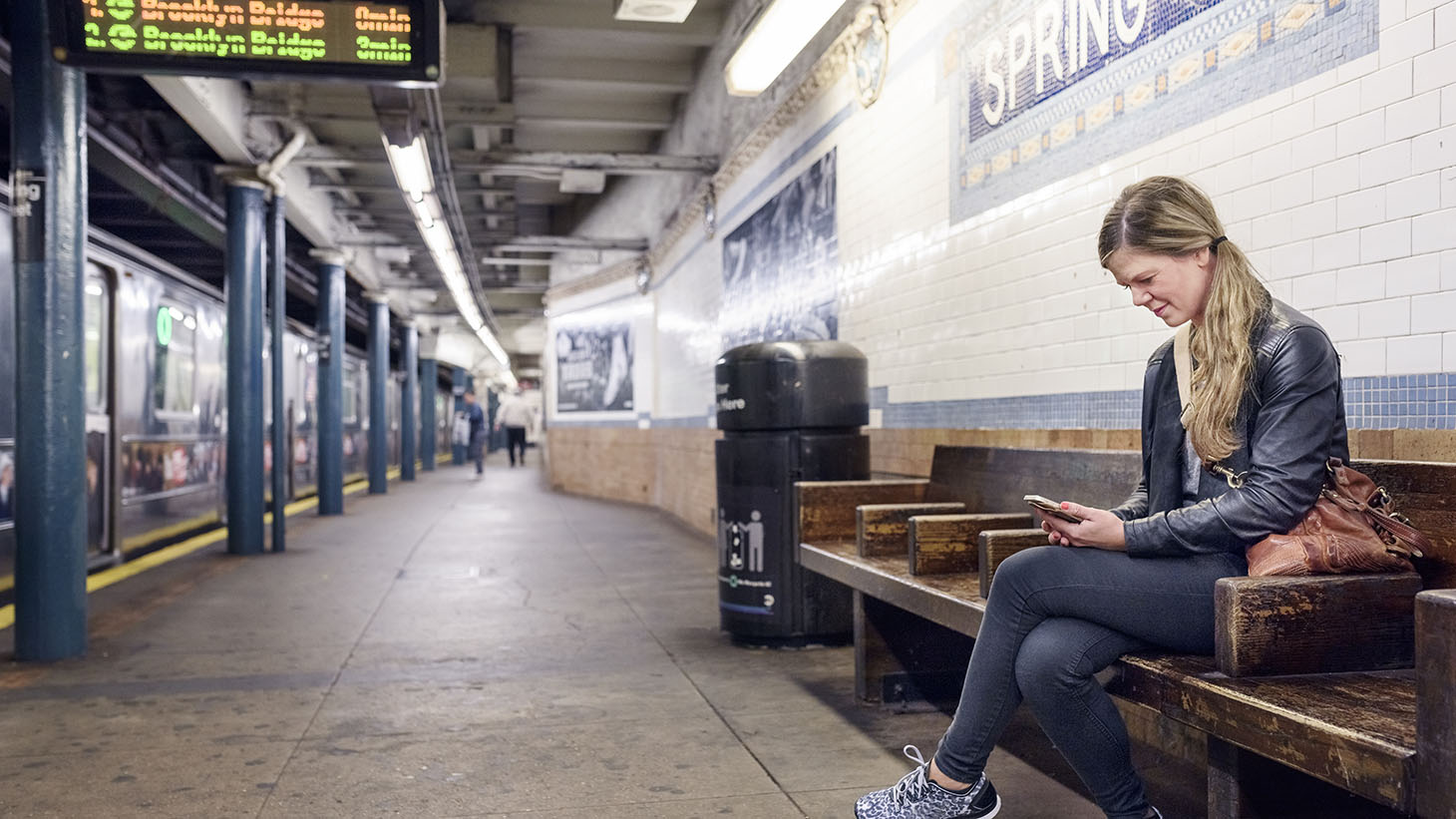 En ung kvinna sitter och väntar på tunnelbanan 