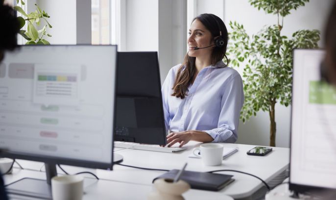 En kvinna med headset pratar i telefon - kundtjänst