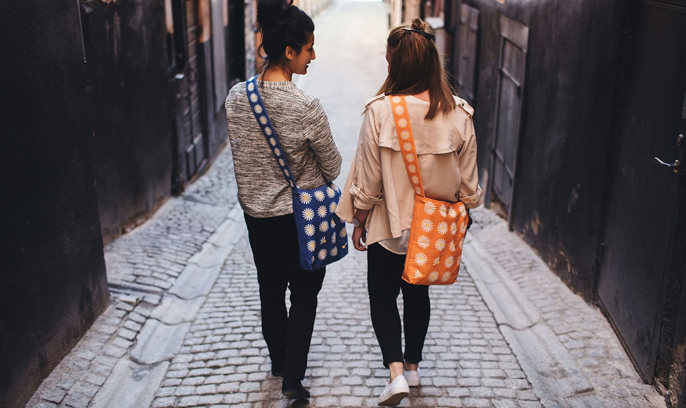 Två unga kvinnor går i en trång gränd i en stad.